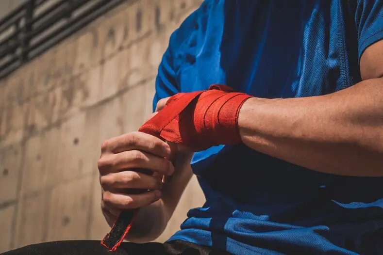 A fighter wraps their hands during training.