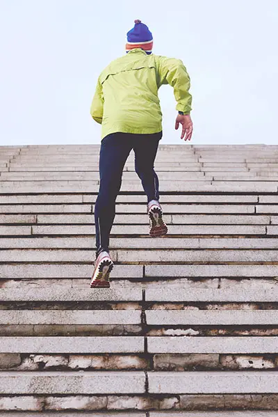 A man running up steps working on building his leg muscles.