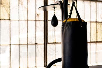 A black and yellow boxing bag hanging in a gym